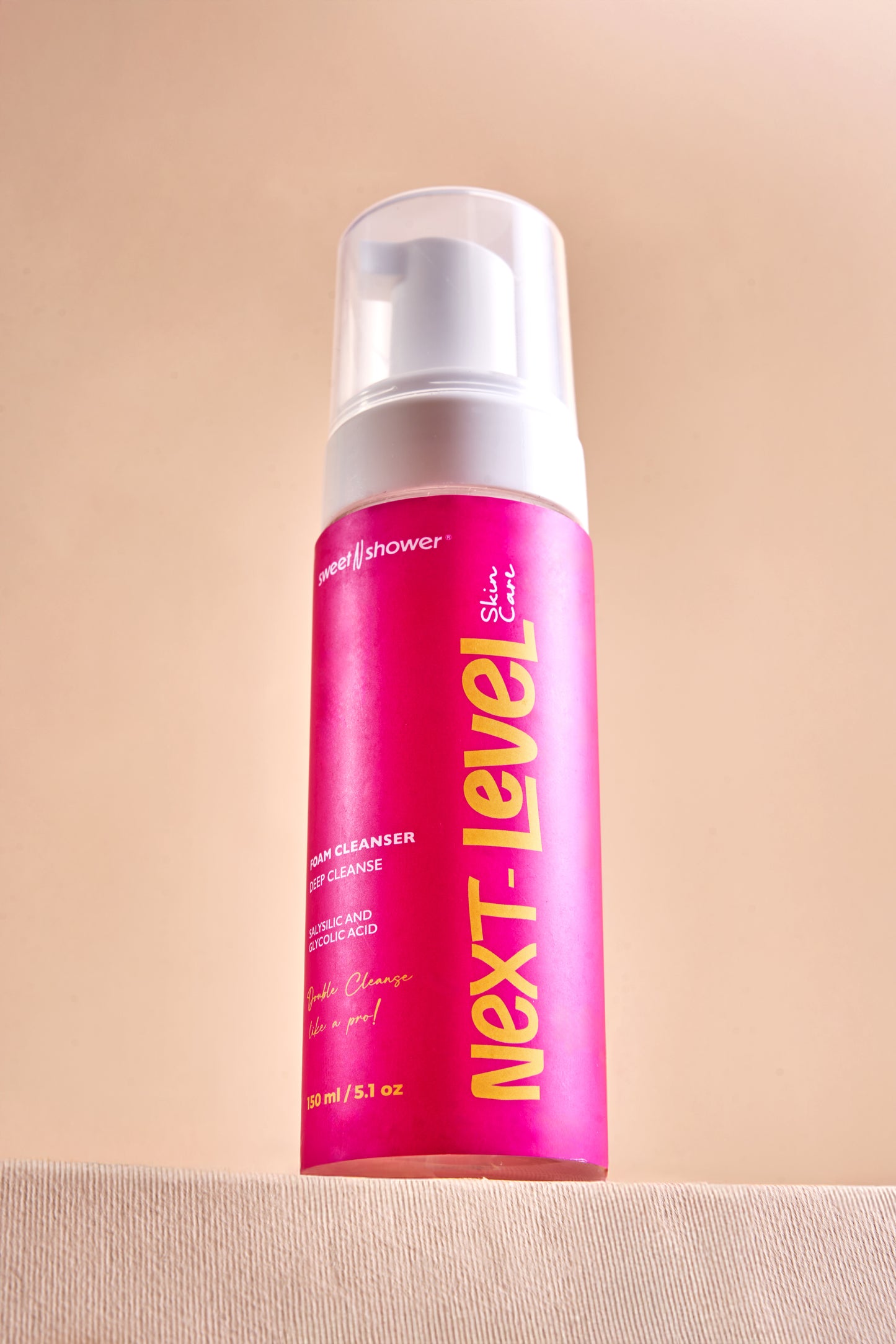 Next Level body wash bottle on a beige background