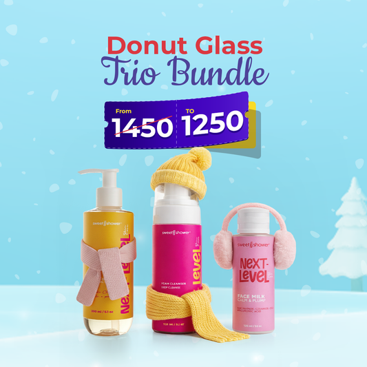 Three Sweetnshower bottles with colorful packaging and winter accessories on a blue background with snowflakes.