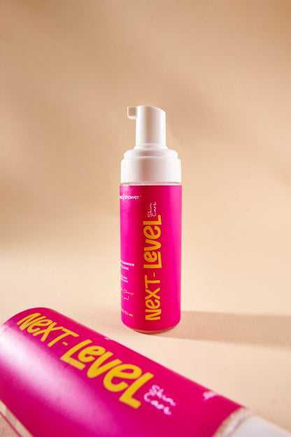 Pink foam bottle with 'Next-Level' branding on a beige background