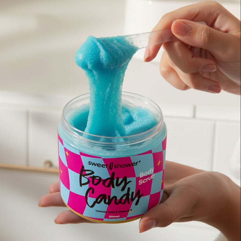 Person scooping blue body scrub from a jar labeled 'Body Candy' with a checkered design.